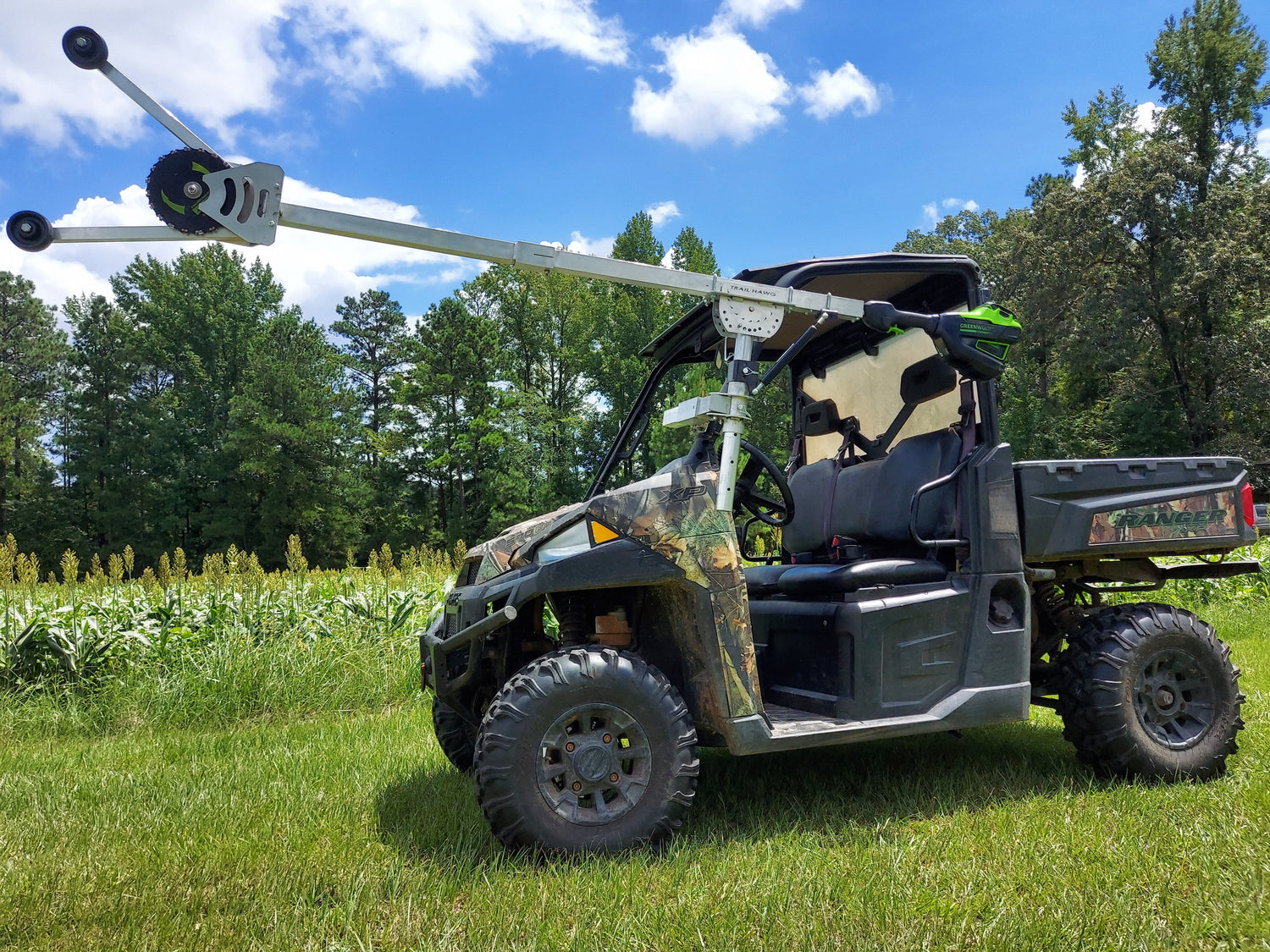 All-terrain vehicle with a mounted camera system in a grassy outdoor setting. Trail Hawg mounted to UTV.